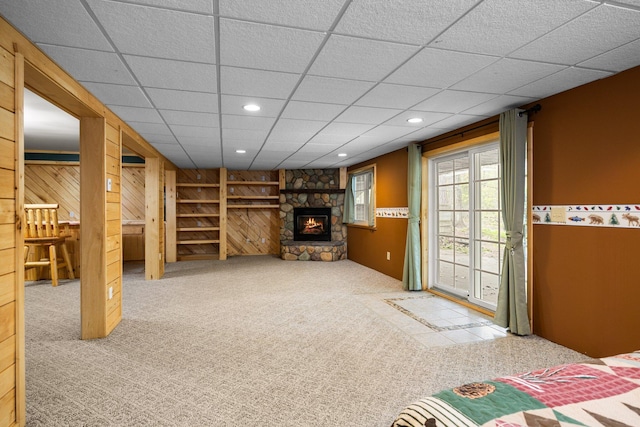 1350 Pine Point Dr, Lewiston, MI 49756 - basement featuring carpet flooring, a stone fireplace, wooden walls, recessed lighting, and a drop ceiling