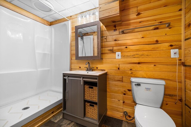 1350 Pine Point Dr, Lewiston, MI 49756 - full bathroom with vanity, a shower stall, toilet, and wooden walls