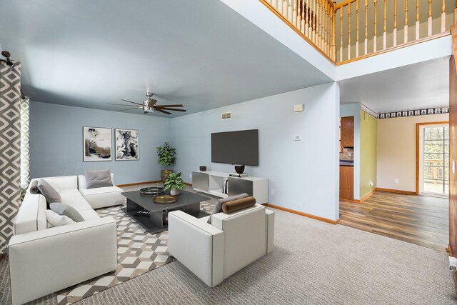 1350 Pine Point Dr, Lewiston, MI 49756 - carpeted living room with a ceiling fan, baseboards, and a towering ceiling