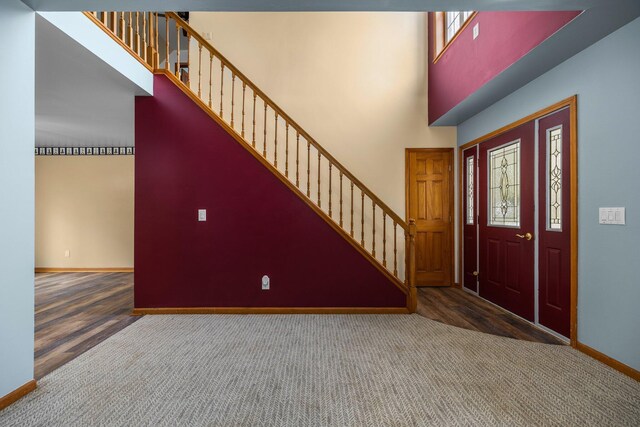 1350 Pine Point Dr, Lewiston, MI 49756 - carpeted foyer featuring baseboards, stairs, a towering ceiling, and wood finished floors