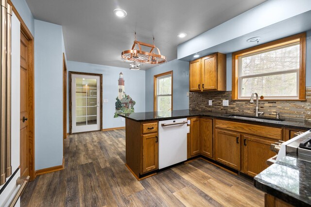 1350 Pine Point Dr, Lewiston, MI 49756 - kitchen with white dishwasher, a sink, a peninsula, brown cabinets, and recessed lighting