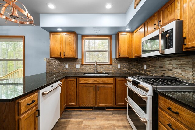 1350 Pine Point Dr, Lewiston, MI 49756 - kitchen featuring white appliances, a sink, a peninsula, brown cabinetry, and recessed lighting