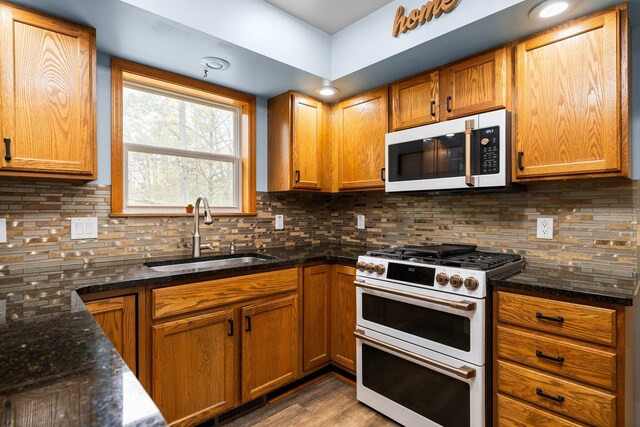 1350 Pine Point Dr, Lewiston, MI 49756 - kitchen featuring white appliances, a sink, dark stone counters, and decorative backsplash