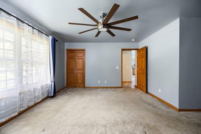 1350 Pine Point Dr, Lewiston, MI 49756 - unfurnished bedroom with light colored carpet, baseboards, and a ceiling fan