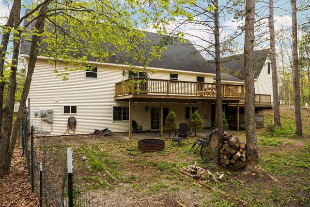 1350 Pine Point Dr, Lewiston, MI 49756 - back of house featuring an outdoor fire pit, a wooden deck, roof with shingles, and a patio area