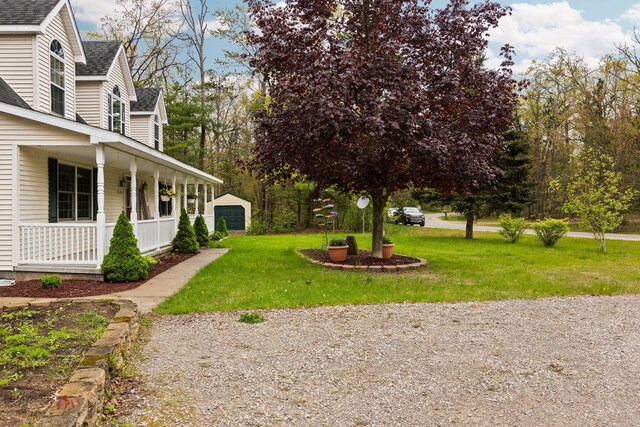 1350 Pine Point Dr, Lewiston, MI 49756 - view of green lawn featuring a porch and a garage