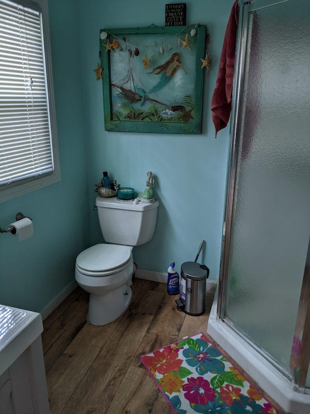 11052 W Higgins Lake Dr, Roscommon, MI 48653 - bathroom featuring baseboards, a stall shower, wood finished floors, and toilet