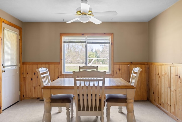 4441 Judy Ave, Lewiston, MI 49756 - dining area with wainscoting, light colored carpet, wooden walls, and ceiling fan