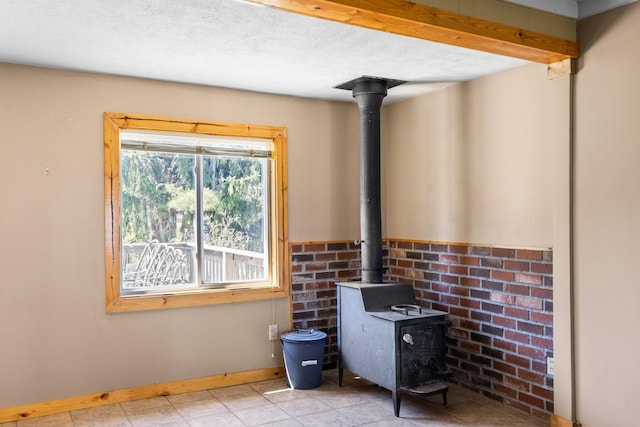 4441 Judy Ave, Lewiston, MI 49756 - detailed view of a wood stove, baseboards, and a textured ceiling