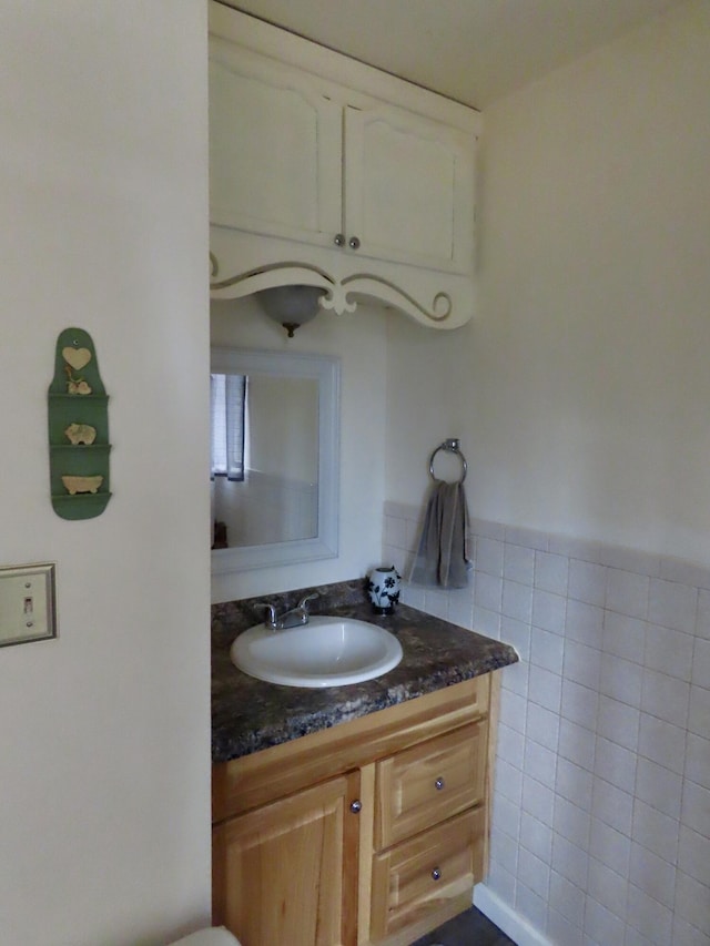 bathroom with vanity and tile walls