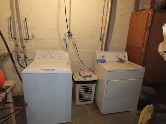 laundry area with independent washer and dryer, concrete block wall, and laundry area