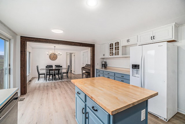 kitchen featuring wooden counters, white cabinets, light wood-style flooring, white fridge with ice dispenser, and blue cabinetry