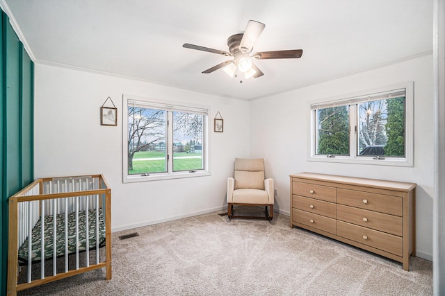 bedroom with light colored carpet, a crib, and multiple windows
