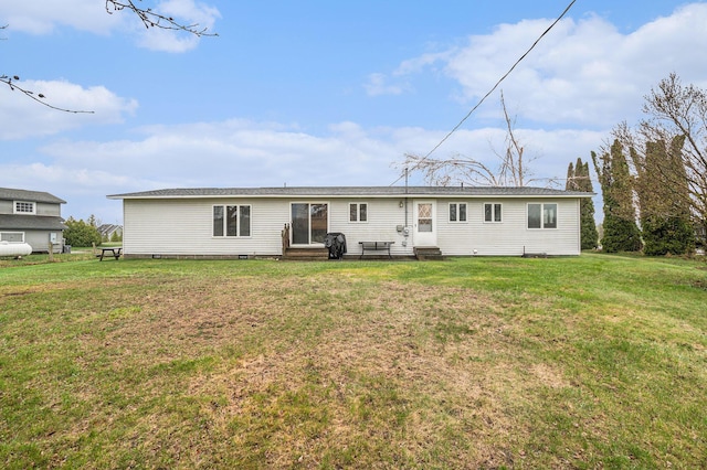 rear view of property with entry steps and a yard