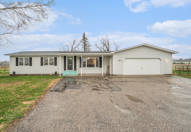 ranch-style house with a garage, a front lawn, fence, entry steps, and driveway