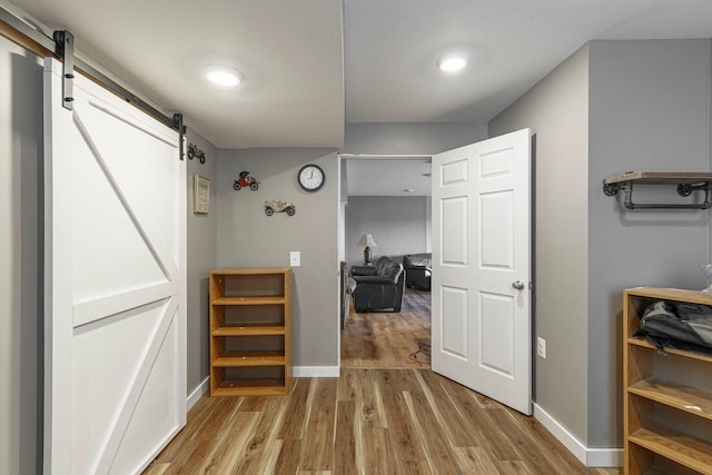 2211 N Kerby Rd, Owosso, MI 48867 - corridor with a barn door, wood finished floors, and baseboards