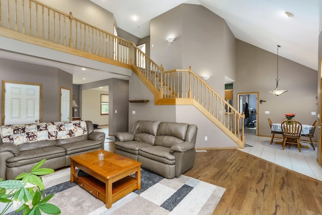 2211 N Kerby Rd, Owosso, MI 48867 - living area featuring stairs, wood finished floors, high vaulted ceiling, recessed lighting, and baseboards