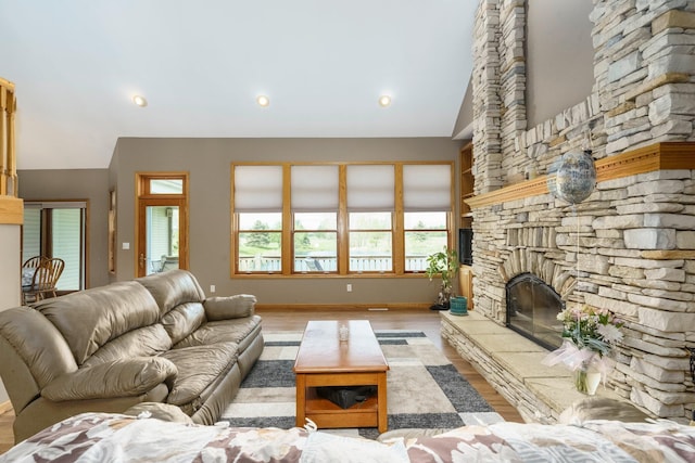 2211 N Kerby Rd, Owosso, MI 48867 - living room with a stone fireplace, wood finished floors, baseboards, and vaulted ceiling