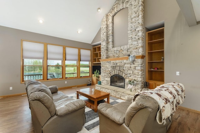 2211 N Kerby Rd, Owosso, MI 48867 - living room featuring baseboards, wood finished floors, a stone fireplace, and vaulted ceiling
