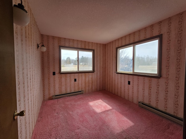 carpeted empty room with baseboard heating and wallpapered walls