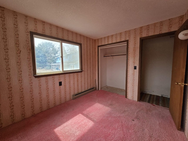 unfurnished bedroom featuring a textured ceiling, a baseboard radiator, wallpapered walls, and carpet