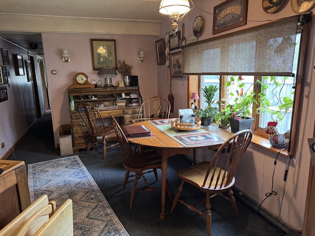 carpeted dining room featuring crown molding