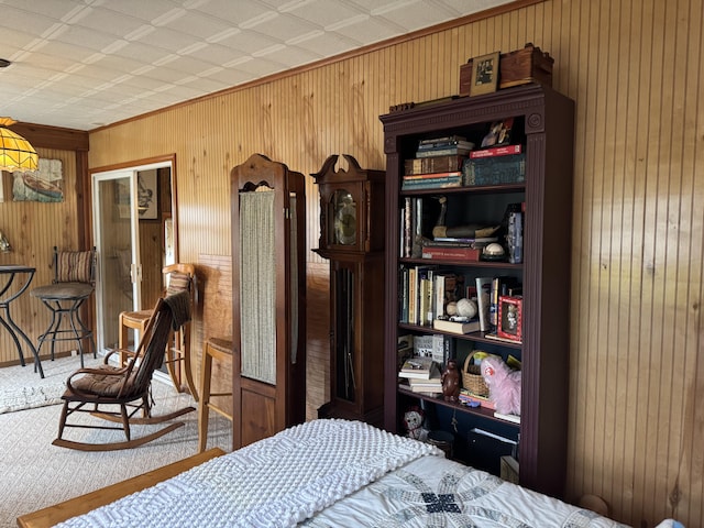 carpeted bedroom featuring wood walls