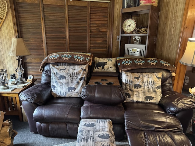 sitting room with carpet floors and wood walls