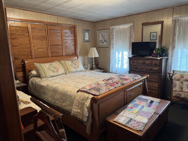 bedroom featuring wooden walls
