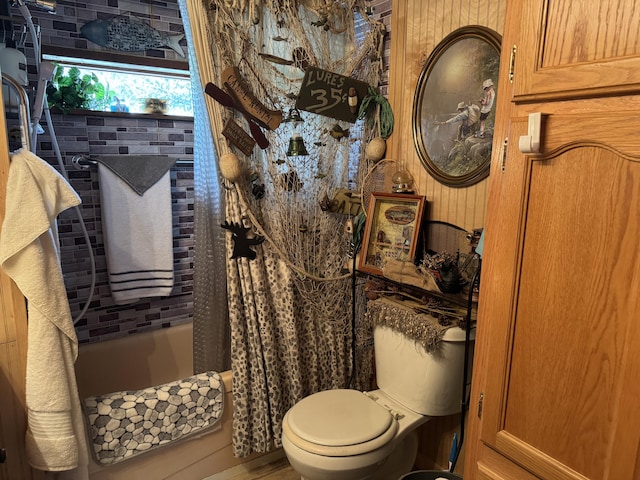 full bathroom featuring toilet and shower / bath combination with curtain