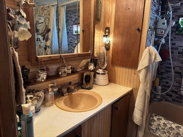 bathroom featuring a bathing tub, wood walls, and vanity
