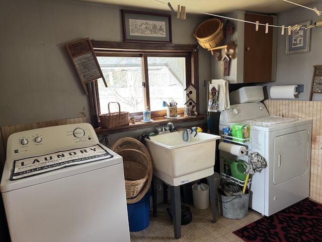 clothes washing area featuring laundry area, a sink, and independent washer and dryer
