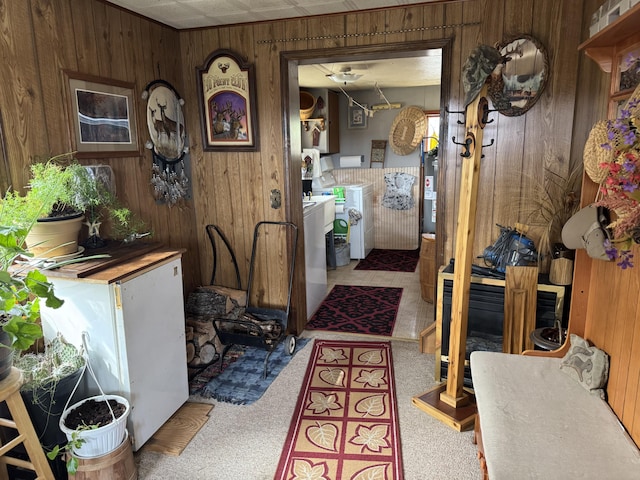 interior space with washer and dryer, wooden walls, carpet flooring, laundry area, and water heater