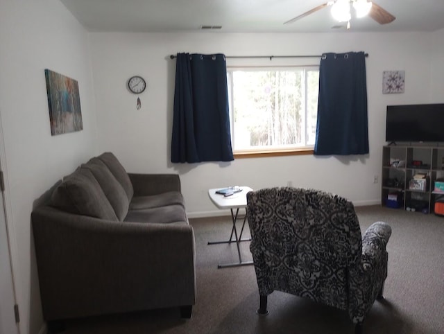 carpeted living area featuring baseboards and a ceiling fan