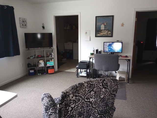 carpeted living area with a sink and baseboards