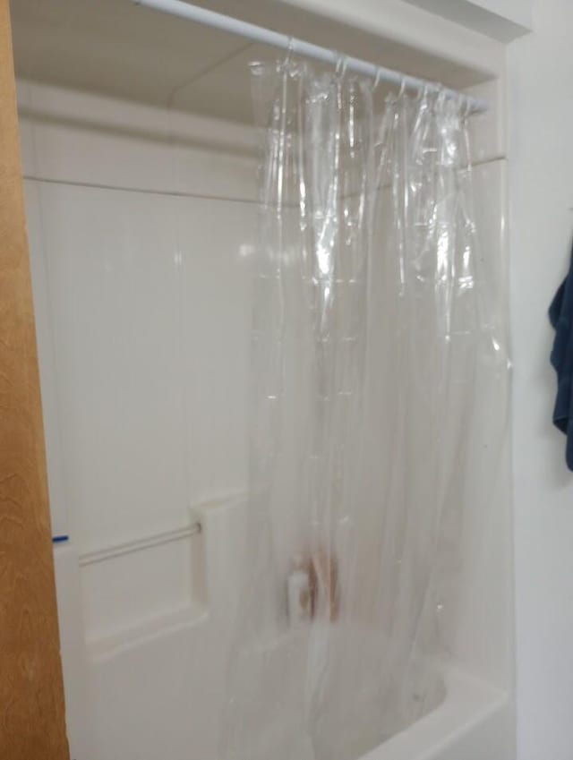 bathroom with shower / bath combination with curtain