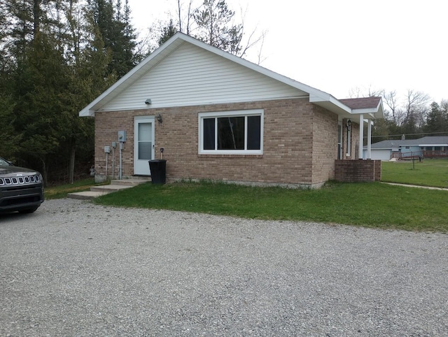 bungalow-style home featuring a front lawn and brick siding