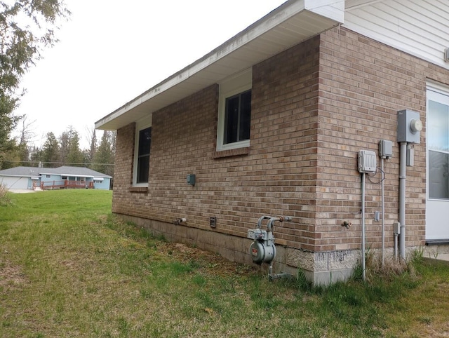 view of home's exterior with a lawn and brick siding