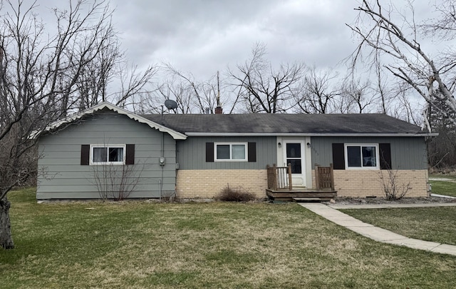 1393 Mackinaw Ave, Cheboygan, MI 49721 - view of front of property with brick siding, a shingled roof, a chimney, and a front lawn