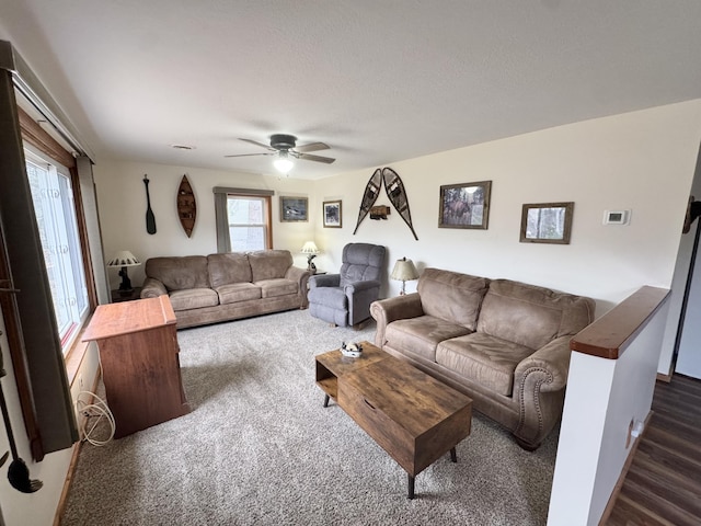 living room with ceiling fan and dark colored carpet