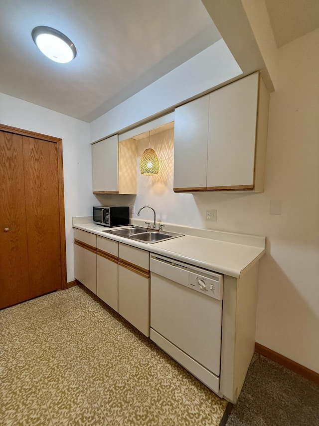 kitchen featuring light countertops, a sink, stainless steel microwave, and dishwasher