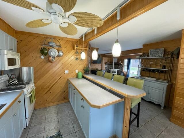 kitchen with white appliances and wooden walls