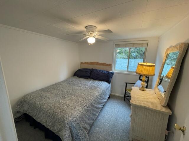 bedroom with ceiling fan, carpet flooring, and baseboards