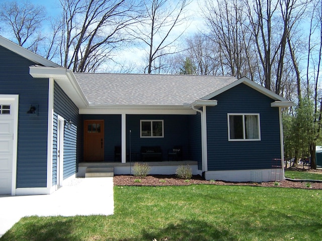 ranch-style home featuring covered porch, a shingled roof, and a front yard