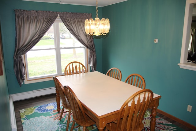 dining room featuring a baseboard heating unit, a chandelier, wood finished floors, and baseboards