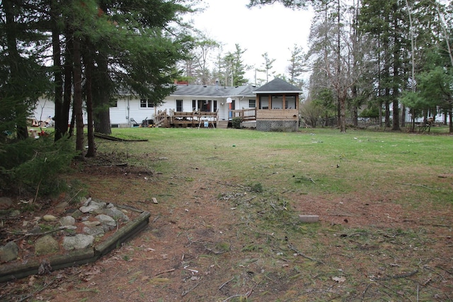 view of front of home featuring a wooden deck and a front yard