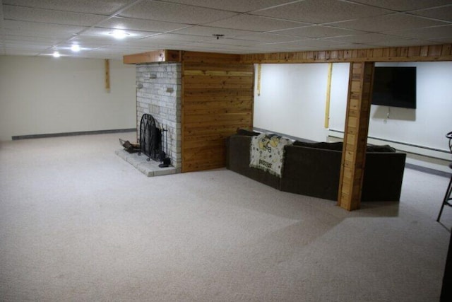 567 Long Rapids Rd, Alpena, MI 49707 - finished basement with carpet floors, a brick fireplace, wood walls, and a drop ceiling