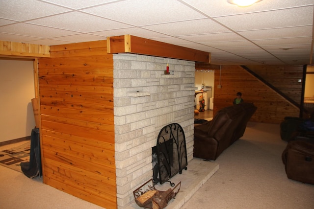 567 Long Rapids Rd, Alpena, MI 49707 - living room with carpet floors, wood walls, a fireplace, and a paneled ceiling