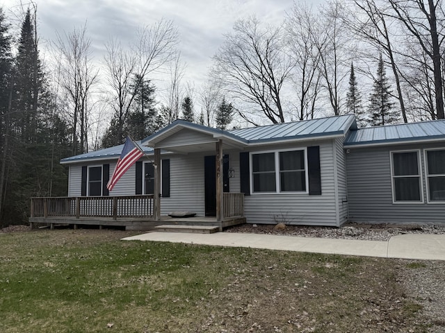3140 Kitchen Rd, Cheboygan, MI 49721 - ranch-style house featuring metal roof, a porch, and a front yard