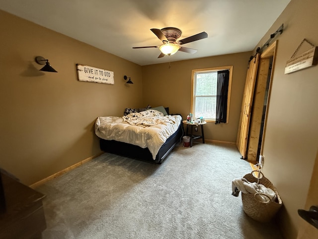 3140 Kitchen Rd, Cheboygan, MI 49721 - carpeted bedroom featuring baseboards, ceiling fan, and a barn door